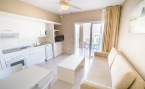 a kitchen and living room with a couch and a table at Los Olivos Beach Resort in Adeje