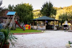 einen Spielplatz mit Rutsche und Spielstruktur in der Unterkunft Casa Maria in Bran