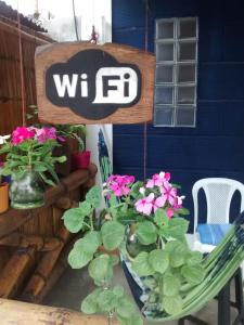 a sign that says wf on a table with flowers at Hostel El Gran Azul Olon in Olón