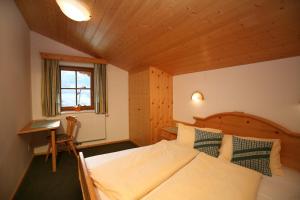 シュラートミンクにあるAppartement Feldlhofのベッドルーム1室(ベッド1台、デスク、窓付)