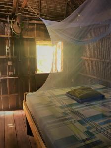 1 dormitorio con 1 cama con mosquitera en Lazy Bones, en Koh Rong Sanloem