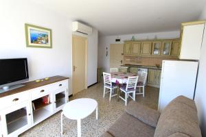 ein Wohnzimmer mit einer Küche und einem Tisch mit Stühlen in der Unterkunft LEON INMO Apartment Bellevue - 10487 in Empuriabrava