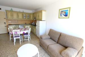 ein Wohnzimmer mit einem Sofa und einem Tisch sowie eine Küche in der Unterkunft LEON INMO Apartment Bellevue - 10487 in Empuriabrava