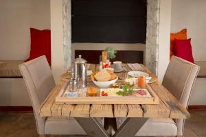 einem Holztisch mit einem Teller Essen drauf in der Unterkunft Driftwood Guesthouse in Swakopmund