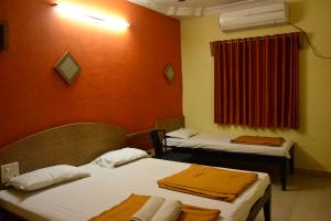 Postel nebo postele na pokoji v ubytování Hotel Madhava
