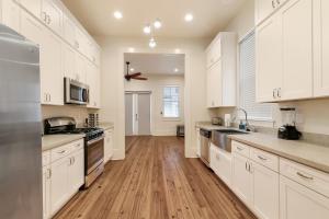 een grote keuken met witte kasten en houten vloeren bij Stunning 3BR on Carondelet by Hosteeva in New Orleans