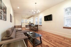 a living room with a couch and a table at Hosteeva 3 BR Cottage Close to St Charles 5 m Ride to FQ in New Orleans