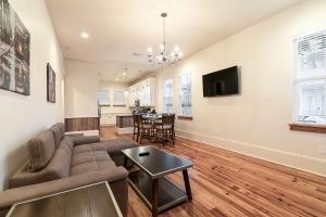 una sala de estar con un sofá y una mesa en Hosteeva 3 BR Cottage Close to St Charles 5 m Ride to FQ, en Nueva Orleans
