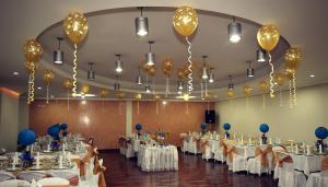 a banquet hall with white tables and balloons at Hotel Santa Isabel 2 in Ipiales