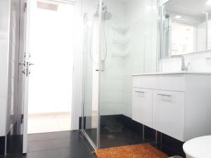 a white bathroom with a shower and a sink at Shave Tsion Apartment in the center Ashdod in Ashdod +39 photos