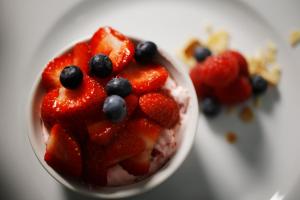 a bowl of fruit salad with strawberries and blueberries at Oxbridge Farm in Netherbury