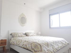 een witte slaapkamer met een bed en een raam bij Shave Tsion Apartment in the center Ashdod in Ashdod