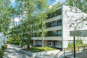 エスポーにある2 room apartment in Tapiolaの目の前に木が立つ事務所