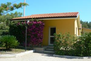 uma casa com flores roxas em frente em Camping & Residence Il Pioppeto em Vasto