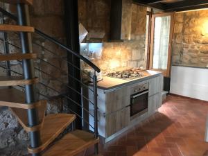 a kitchen with a stove top oven next to a staircase at Palazzo Urbani in Orvieto