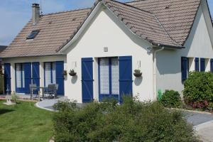 una casa con persianas azules y techo en Une Chambre D'Hote Yvetot, en Yvetot