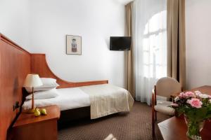 a hotel room with a bed and a chair at Dom Muzyka in Gdańsk