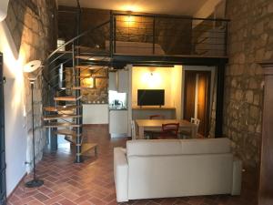 a living room with a white couch and a spiral staircase at Palazzo Urbani in Orvieto
