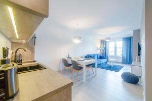 a kitchen and living room with a table and chairs at DP Apartament Polanki Park in Kołobrzeg