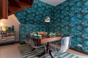 une salle à manger avec une table et un papier peint vert dans l'établissement bairro alto view point 3 bedrooms chalet, à Lisbonne