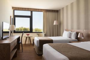 a hotel room with two beds and a television at Salinas del Almiron Resort Termal in Termas de Almiron