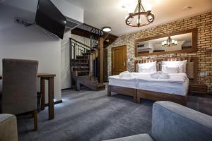 a bedroom with a bed and a brick wall at Hotel & Spa **** Kasztel Uniejów in Uniejow