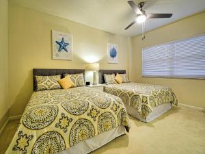 a bedroom with two beds and a ceiling fan at Regatta Beach Club C1009 2373 in Clearwater Beach +16 photos