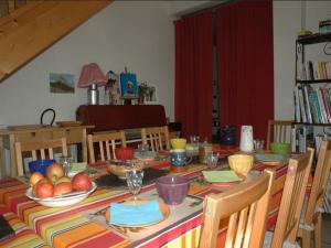 una mesa de comedor con frutas y platos. en Chalet l'Angélique, en Bolquere Pyrenees 2000