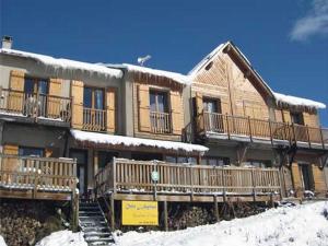 d'un grand bâtiment en bois recouvert de neige. dans l'établissement Chalet l'Angélique, à Bolquère-Pyrénées 2000