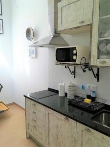 cocina con fregadero y microondas en Casinhas da Ajuda nº25, en Lisboa