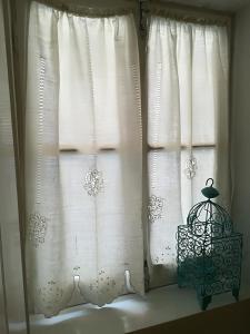 a window with white curtains and a lamp next to it at Casinhas da Ajuda nº25 in Lisbon