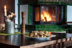a plate of food on a table in front of a fireplace at Hotel Karwendelblick in Urfeld +22 photos
