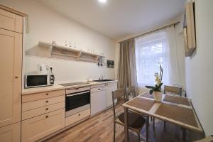 a kitchen with a table and a microwave and a table with chairs at Bluestars Home in Karlovy Vary