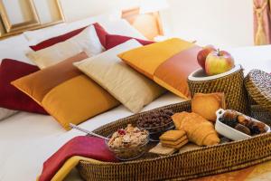 RondissoneにあるHotel Rondissoneの枕が置かれたベッドの上に食べ物が詰まったトレイ +3枚の写真