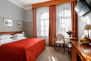 a hotel room with a bed with a red blanket at Dom Muzyka in Gdańsk