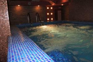 a jacuzzi tub with blue tiles in a building at Green Hisar Hotel Family in Hisarya