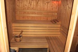 a sauna with a wooden tub and a wooden bucket at Green Hisar Hotel Family in Hisarya