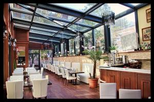 a restaurant with white chairs and tables and a bar at Hotel Art in Buzău
