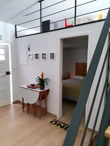 um quarto com uma cama e uma mesa com uma mesa de sidx em Casinhas da Ajuda nº 27 em Lisboa