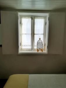 a bedroom with a window with a bird cage at Casinhas da Ajuda nº 27 in Lisbon