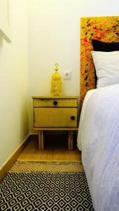 - une chambre avec un lit et une table de chevet à côté d'un lit dans l'établissement Casinhas da Ajuda nº 27, à Lisbonne