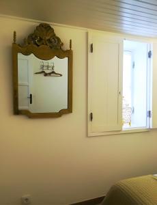un miroir sur un mur à côté d'une fenêtre dans l'établissement Casinhas da Ajuda nº 27, à Lisbonne
