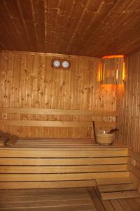 a wooden sauna with a tub and two clocks at Green Hisar Hotel Family in Hisarya