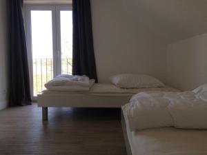 two beds in a room with a window at DHH Claire_SAWO in Ostseebad Karlshagen