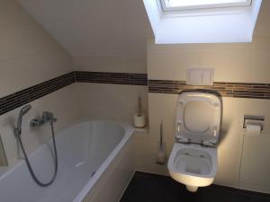 a bathroom with a bath tub and a toilet at DHH Claire_SAWO in Ostseebad Karlshagen