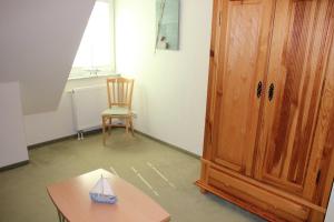 a room with a table and a chair and a wooden cabinet at Fewo An der Duene 5b_BAER in Karlshagen