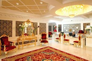 Zimmer mit einem Tisch, Stühlen und einem Kronleuchter in der Unterkunft Royal Olympic Hotel in Kiew