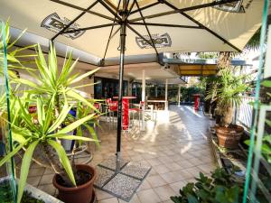 a patio with an umbrella and some plants at Hotel Elba in Rimini