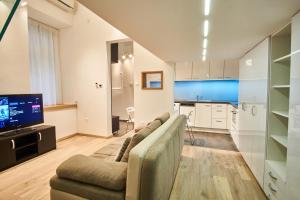 ein Wohnzimmer mit einem Sofa und einem TV in der Unterkunft V27 Apartment | hostAID in Budapest