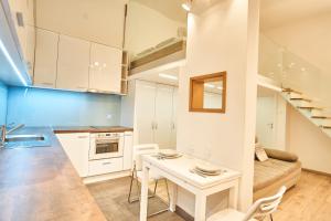 eine Küche und ein Wohnzimmer mit einem Tisch und einer Treppe in der Unterkunft V27 Apartment | hostAID in Budapest